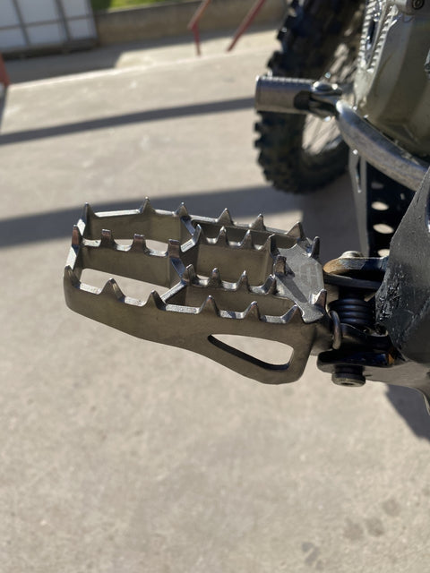 KTM with High-Strength Titanium Foot Pegs for enhanced grip and stability.